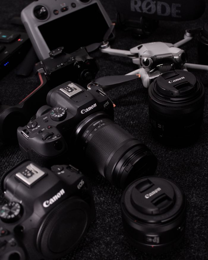 A collection of professional photography gear including cameras, lenses, and drones captured in a studio setting.